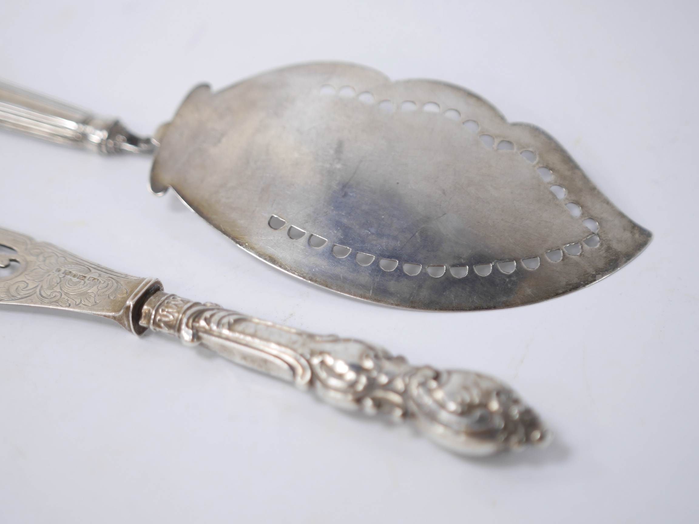 A George III Irish silver fish slice, Joseph Jackson, Dublin, 1801, 30.5cm and a smaller Victorian silver fish slice. Condition - poor to fair